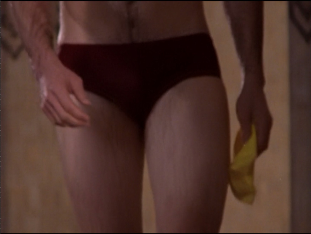 A dude's legs and crotch in an itsy bitsy speedo