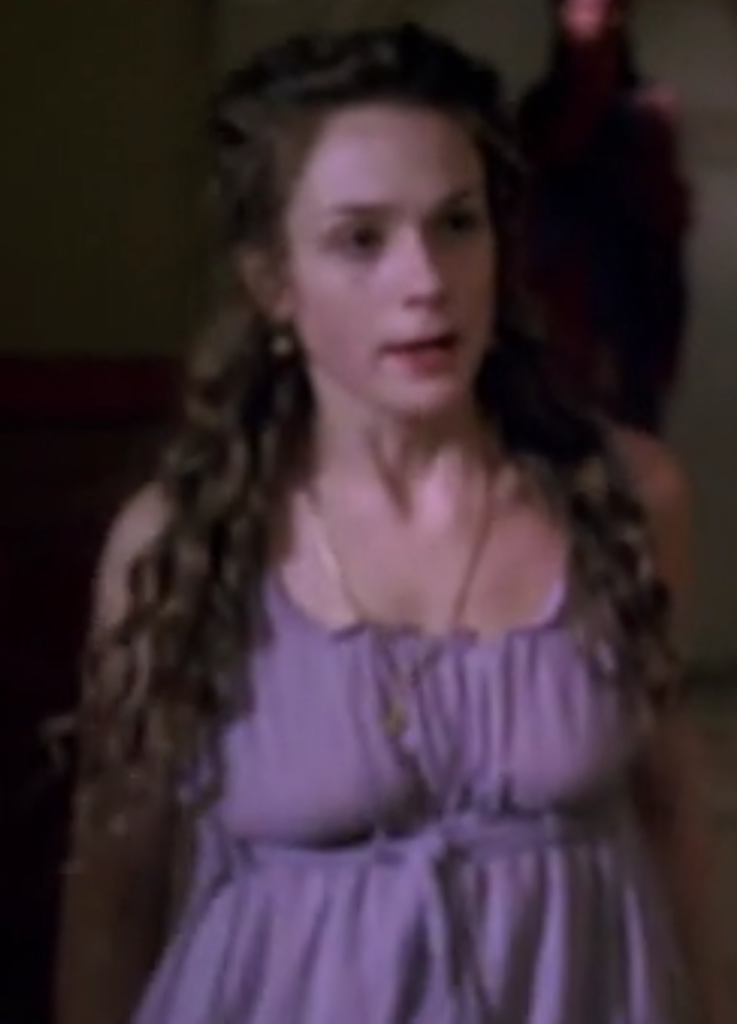 A blurry picture of Octavia in a purple dress, with very long mermaid hair curls.
