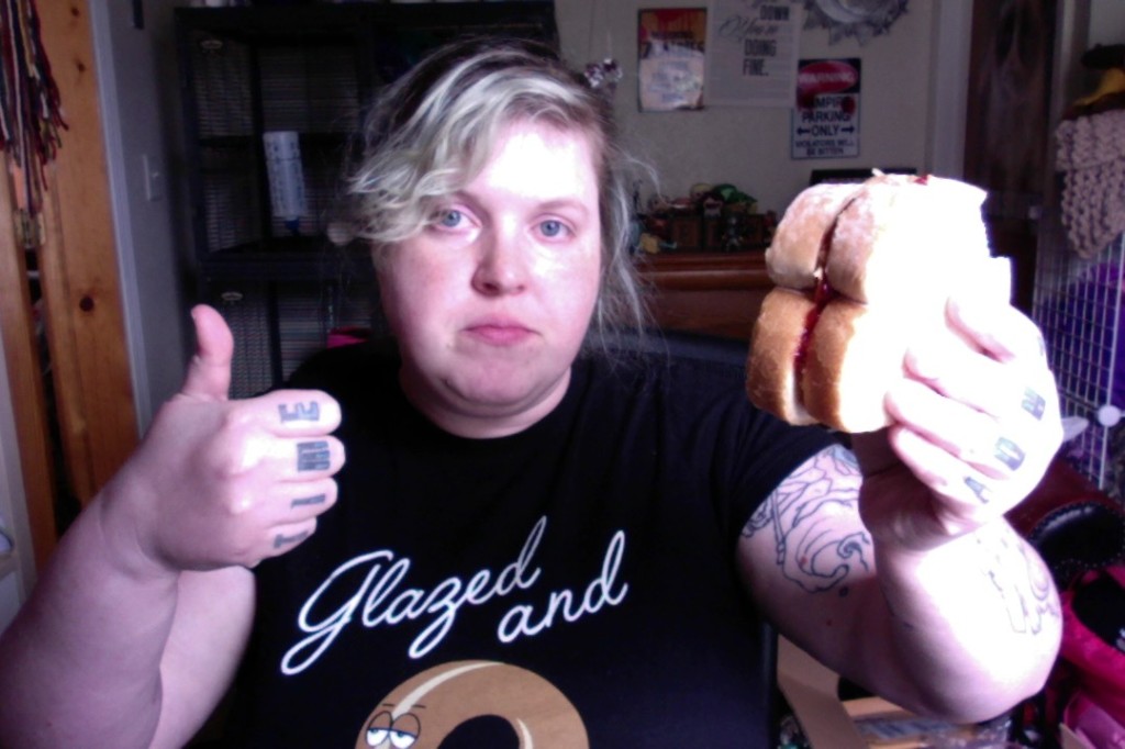 Me, holding a peanut butter and jelly sandwich (and the peanut butter is crunchy. You can't see that in the photo, but I thought you might be curious). Anyway, it's a picture of me holding a peanut butter and jelly sandwich and giving a thumbs up. My eyes are very red.