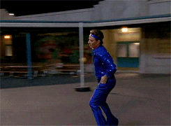 Animated gif of Bryan Cranston rollerskating in a sparkly blue sequined costume on Malcolm In The Middle