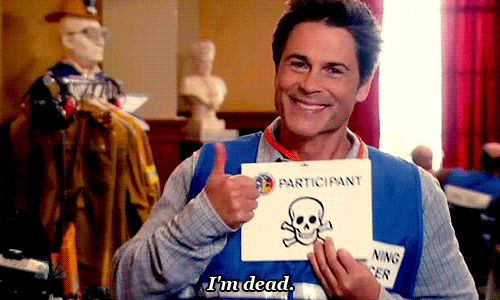 Chris Traeger in the "Emergency Response" episode of Parks and Rec, holding a card with a skull and crossbones on it and giving a thumbs up while saying, "I'm dead."