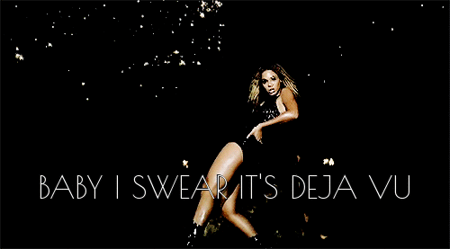 Beyonce in the "Deja Vu" video, dressed in black against a black background with fireworks or something glittery happening behind her, I don't have my glasses on. What's important is that the words across the bottom say "Baby I swear it's deja vu."