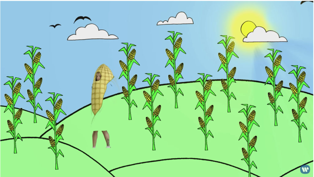 Beebs is wearing his corn suit in an animated scene of corn growing on a hill. Because the leaves of the corn suit are green, they're not visible and blend in badly with the background.